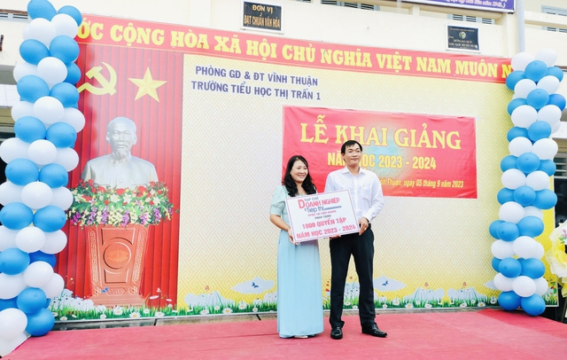 Ông Nguyễn Văn Dương, Phóng viên Tạp chí Doanh nghiệp và Tiếp thị, VPĐD tại Hậu Giang trao bảng tượng trưng 1.000 quyển vở cho Trường Tiểu học thị trấn 1.