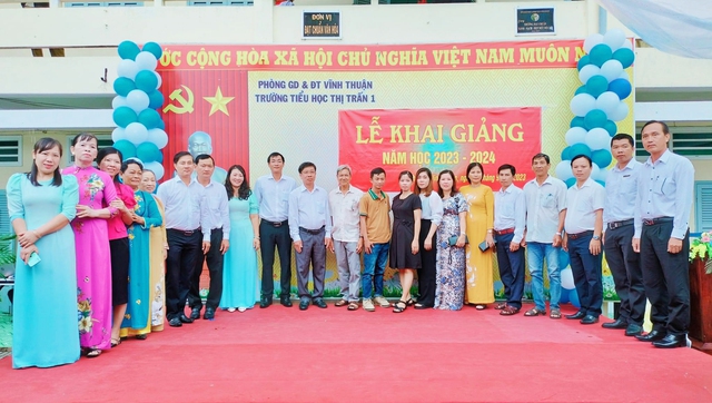 Các đại biểu chụp ảnh lưu niệm với trao Giấy khen của UBND huyện Vĩnh Thuận Trường Tiểu học thị trấn 1.