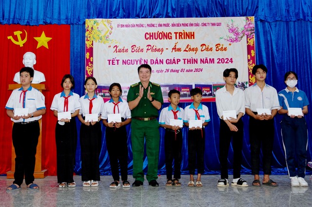 Đại tá Lê Văn Anh, Phó Chính ủy, BĐBP tỉnh trao học bổng cho các em học sinh trong chương trình &quot;Nâng bước em tới trường&quot;.