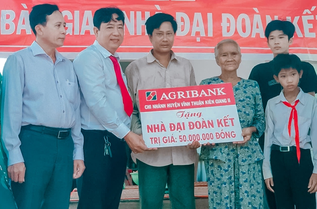 Ông Trương Quốc Phục, Phó Giám đốc Agribank Vĩnh Thuận cùng Ủy ban MTTQ huyện bàn giao nhà Đại đoàn kết cho gia đình bà Huỳnh Thị Cúc.