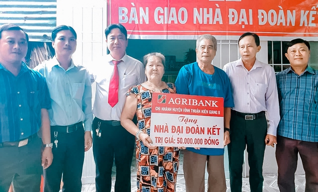 Ông Trương Quốc Phục, Phó Giám đốc Agribank Vĩnh Thuận cùng Ủy ban MTTQ huyện bàn giao nhà Đại đoàn kết cho gia đình bà Lê Thị Được.