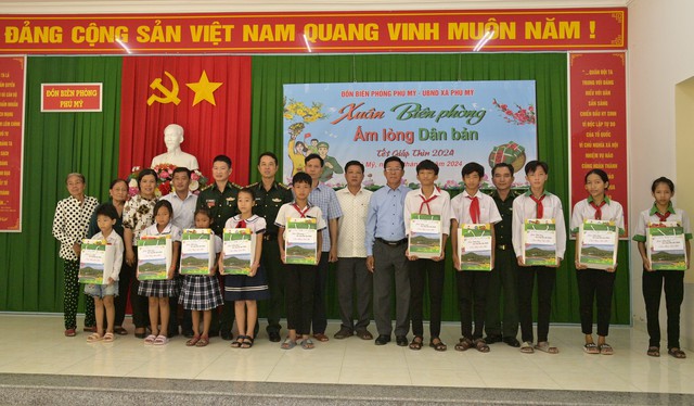 Đại tá Doãn Đình Tránh - Phó Chính ủy BĐBP tỉnh Kiên Giang trao quà cho học sinh nghèo trên địa bàn xã Phú Mỹ, huyện Giang Thành.