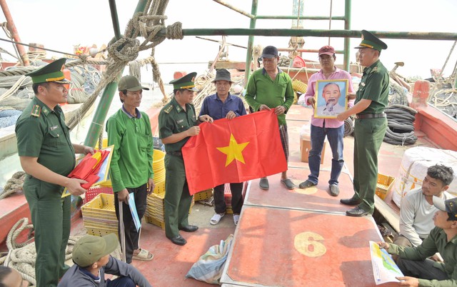 Ban chỉ huy đồn Biên phòng Tây Yên trao ảnh Bác, cờ Tổ quốc chúc ngư dân vươn khơi bám biển an toàn.