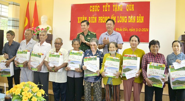 Đại tá Huỳnh Văn Đông và chính quyền phường Pháo Đài, trao quà tết của Bộ Tư lệnh BĐBP cho bà con nghèo trên địa bàn.