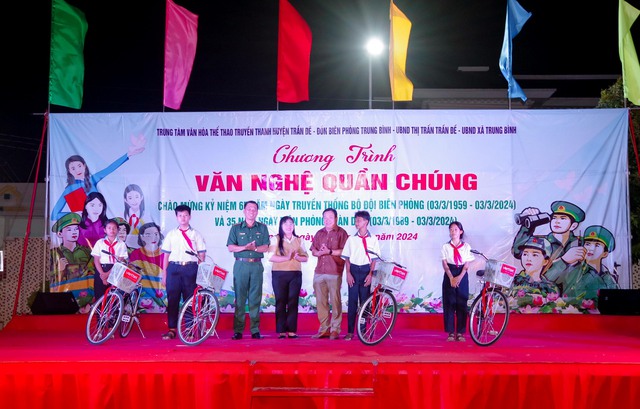 Đại diện lãnh đạo Phòng Chính trị BĐBP tỉnh và UBND, thị Trấn Trần Đề, UBND xã Trung Bình, huyện Trần Đề trao xe đạp cho các em học sinh.