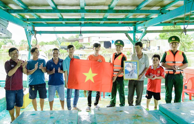 Lực lượng đoàn viên, thanh niên Bộ đội Biên phòng tỉnh Kiên Giang tặng cờ, ảnh Bác cho ngư dân.