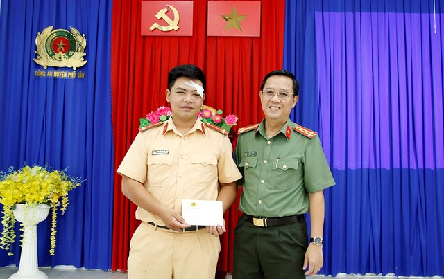 Đại tá Lê Phú Thạnh, Phó Giám đốc Công an tỉnh và trao kinh phí hỗ trợ Trung uý Nguyễn Quốc Thái.