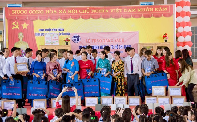 Đại diện Quỹ Phượng Hoàng TP Hồ Chí Minh trao tặng &quot;Tủ sách lớp em&quot; và túi đựng sách cho 22 trường Tiểu học và THCS trên địa bàn huyện.