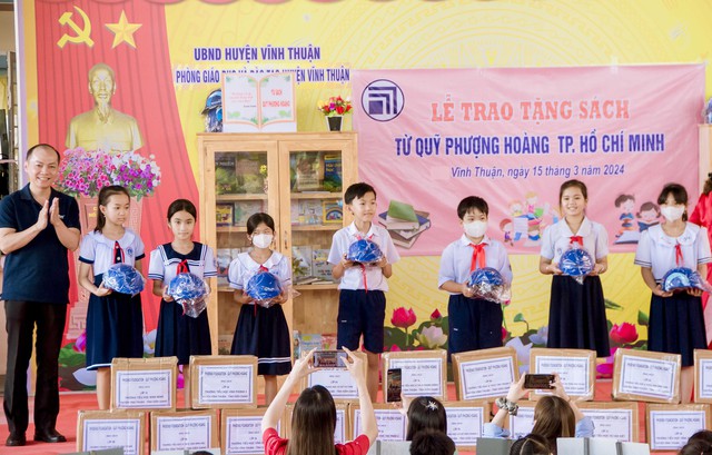 Đại diện Quỹ Phượng Hoàng TP Hồ Chí Minh trao tặng 120 nón bảo hiểm cho các em học sinh Trường Tiểu học thị trấn 1.