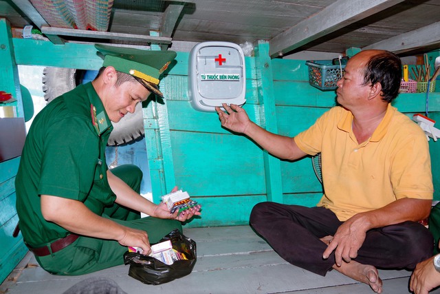 Cán bộ Hải đội 2 Biên phòng, BĐBP tỉnh Sóc Trăng lắp đặt tủ thuốc cho tàu cá ngư dân.