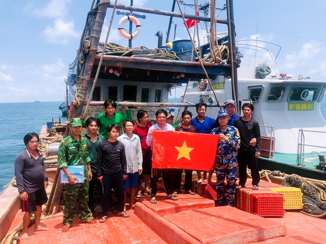 Tổ công tác tuyên truyền kết hợp tặng cờ tổ quốc cho ngư dân.