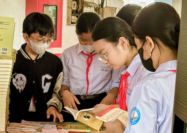 Các em học sinh thích thú đọc sách lý luận chính trị được NXB Chính trị quốc gia Sự thật - Chi nhánh Cần Thơ trưng bày tại Ngày hội.