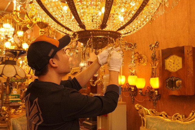 Anh Thịnh - chủ cửa hàng đồ nội thất Châu Âu tỉ mỉ lau chùi, kiểm tra lại từng món đồ trước khi đưa ra giao dịch.