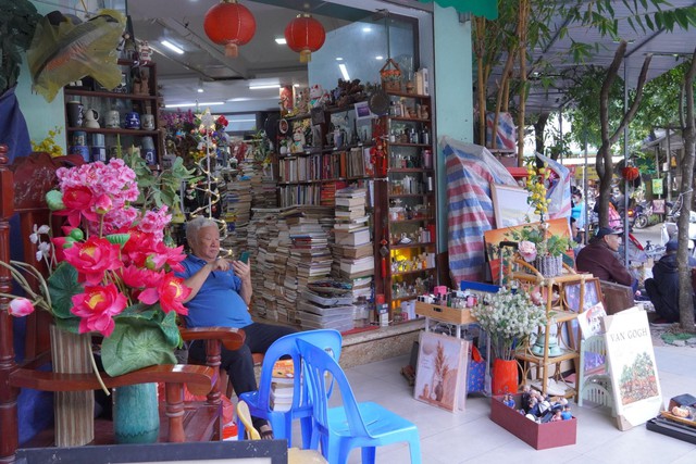 Một gian hàng kết hợp sách cũ và đồ gốm sứ, nơi những cuốn sách đã ngả màu thời gian nằm cạnh các món đồ gốm mang dấu ấn thủ công xưa.