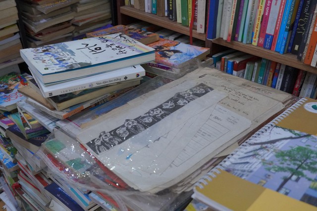 Sách cũ, bản thảo và giấy tờ đã ngả màu thời gian được xếp chồng trong cửa hàng.