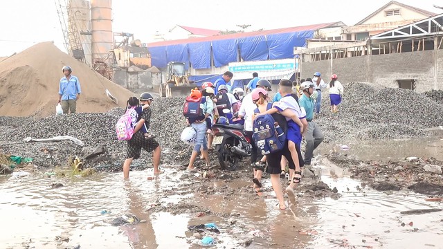 Công an Cần Thơ hỗ trợ người dân đi lại an toàn trong triều cường- Ảnh 2.