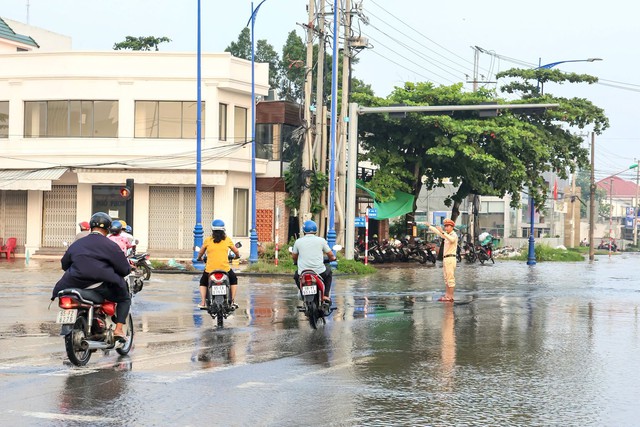 Công an Cần Thơ hỗ trợ người dân đi lại an toàn trong triều cường- Ảnh 3.