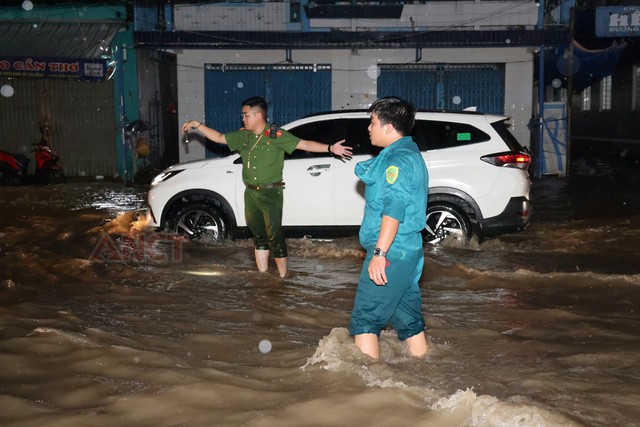 Công an phường Cái Khế hỗ trợ người dân qua khu vực ngập sâu do triều cường- Ảnh 1.