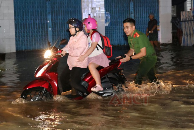 Công an phường Cái Khế hỗ trợ người dân qua khu vực ngập sâu do triều cường- Ảnh 2.