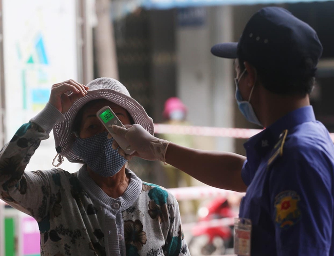 Trước khi vào chợ mua hàng, người dân sẽ được đo nhiệt độ. Ảnh: Lê Bảo, Minh Thuỳ (Bộ Y tế)