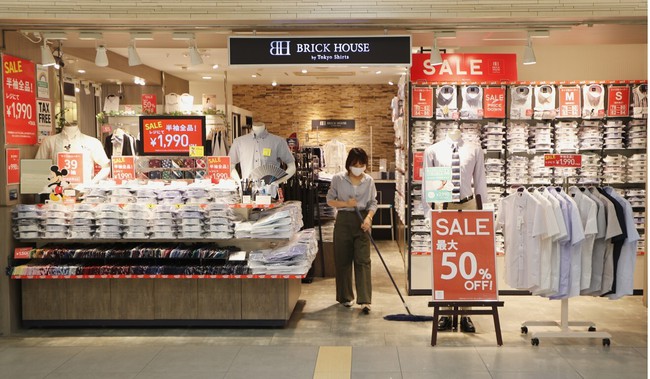 Một nhân viên lau sàn tại cửa hàng trong một trung tâm mua sắm yên tĩnh ở Tokyo. Ảnh: AP